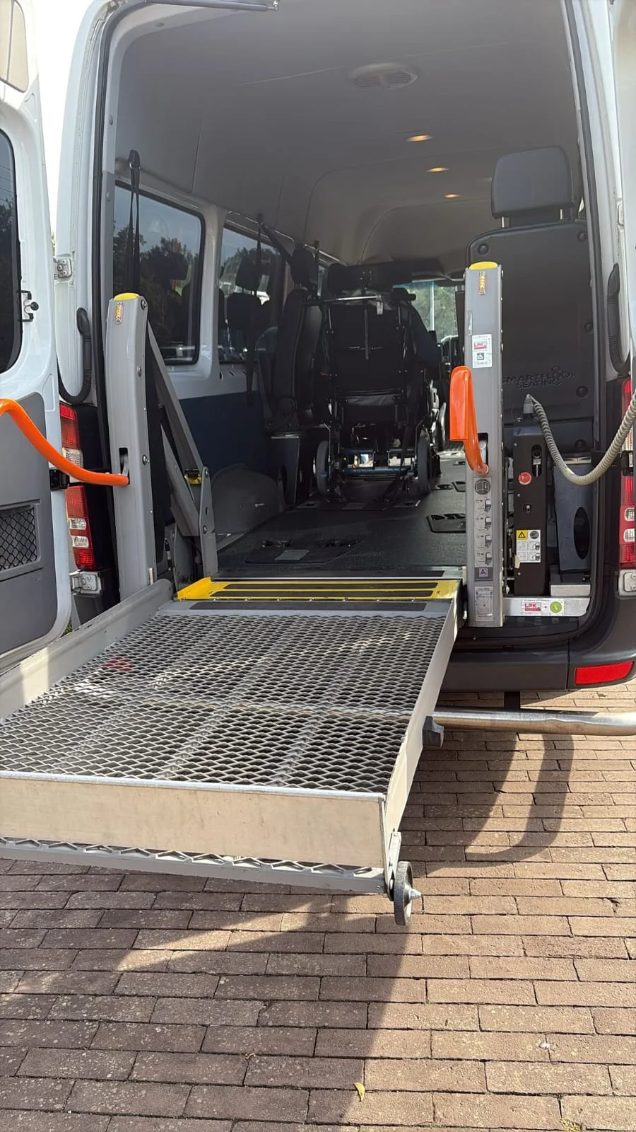 Open achterzijde van de taxibus met uitgeklapte rolstoellift